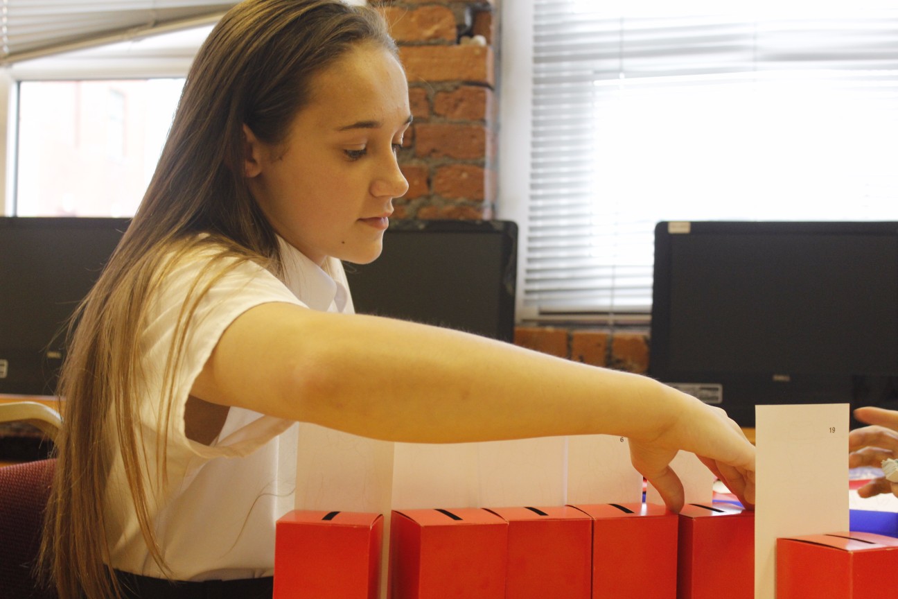 Young girl moving red boxes.
