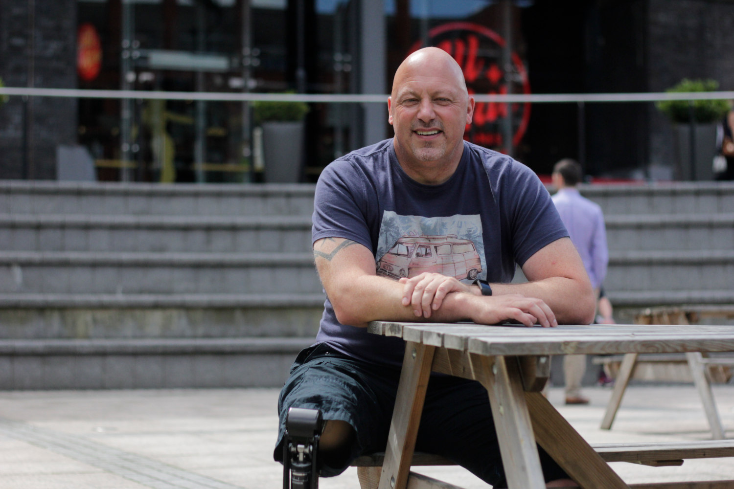 Man sat at outdoor table.