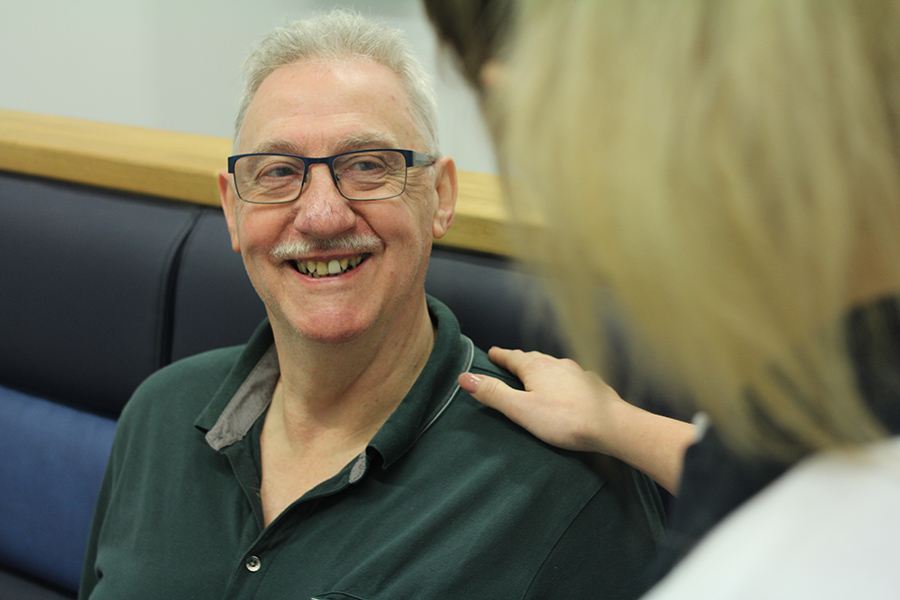 Older gentleman smiling to Chiropody specialist.