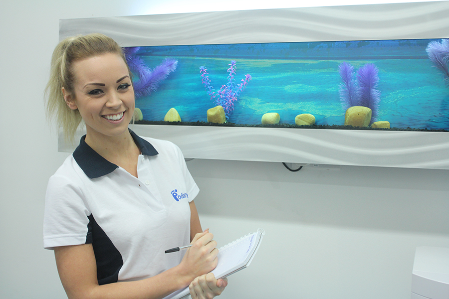 Smiling young lady in Chiropody polo.