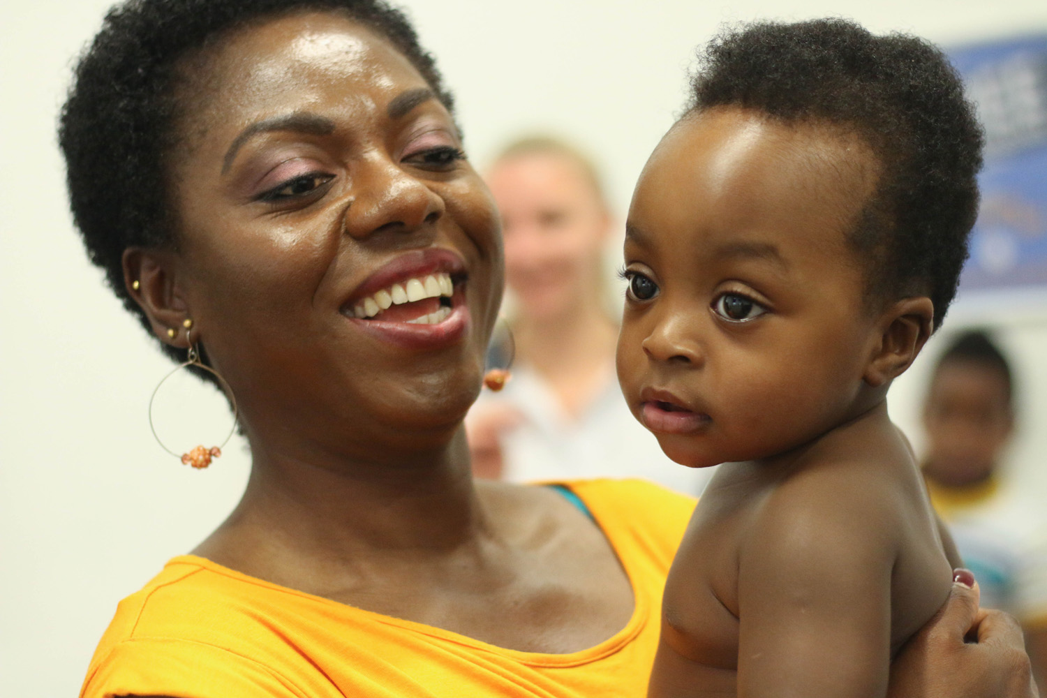 Smiling woman holding baby.