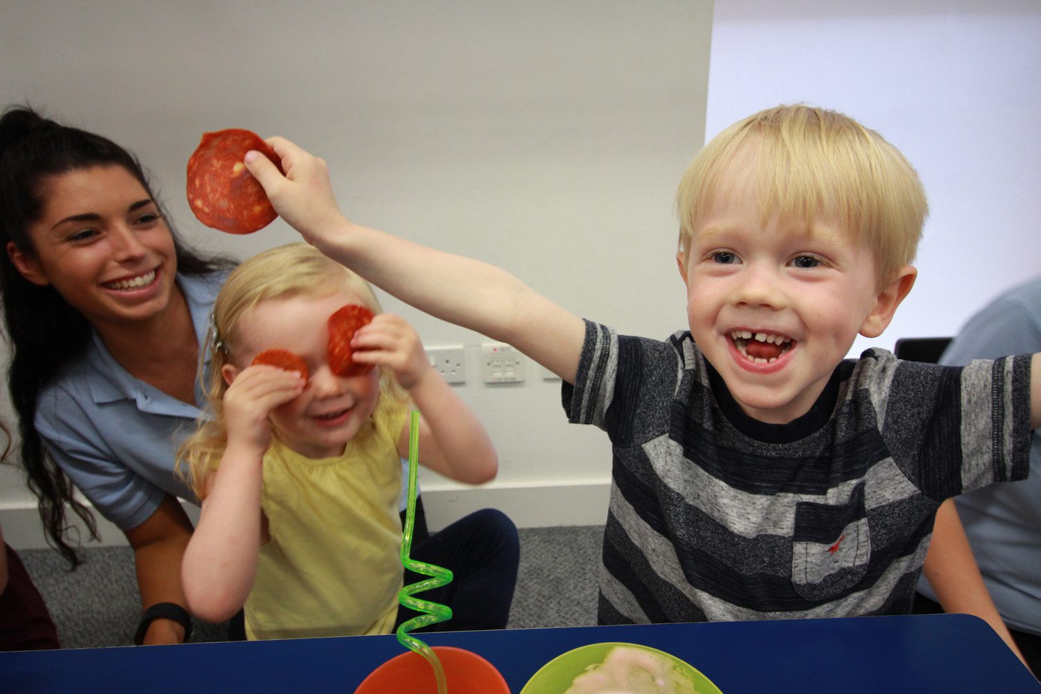 Boy holding sliced pepperoni.