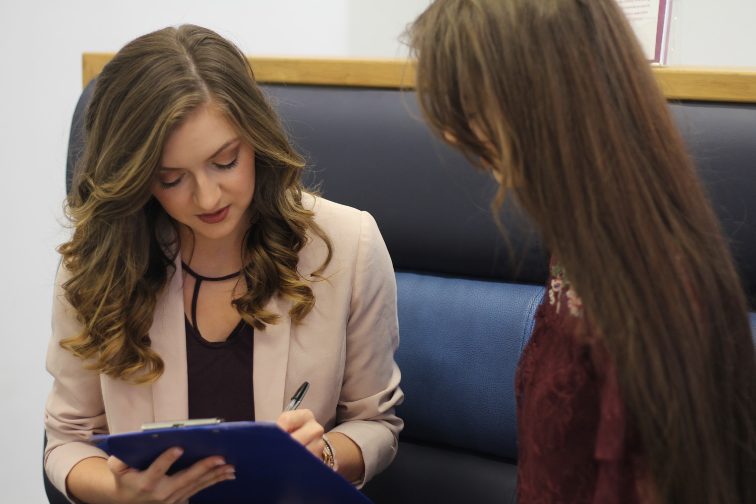 Therapist making notes with her clipboard.