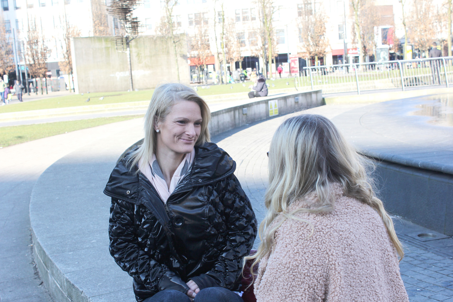 Two women sat at Picadilly Gardens.