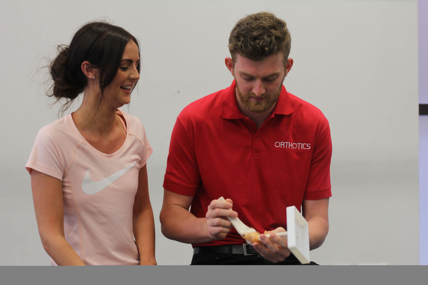 Orthotics therapist showing a ball and socket joint to patient.