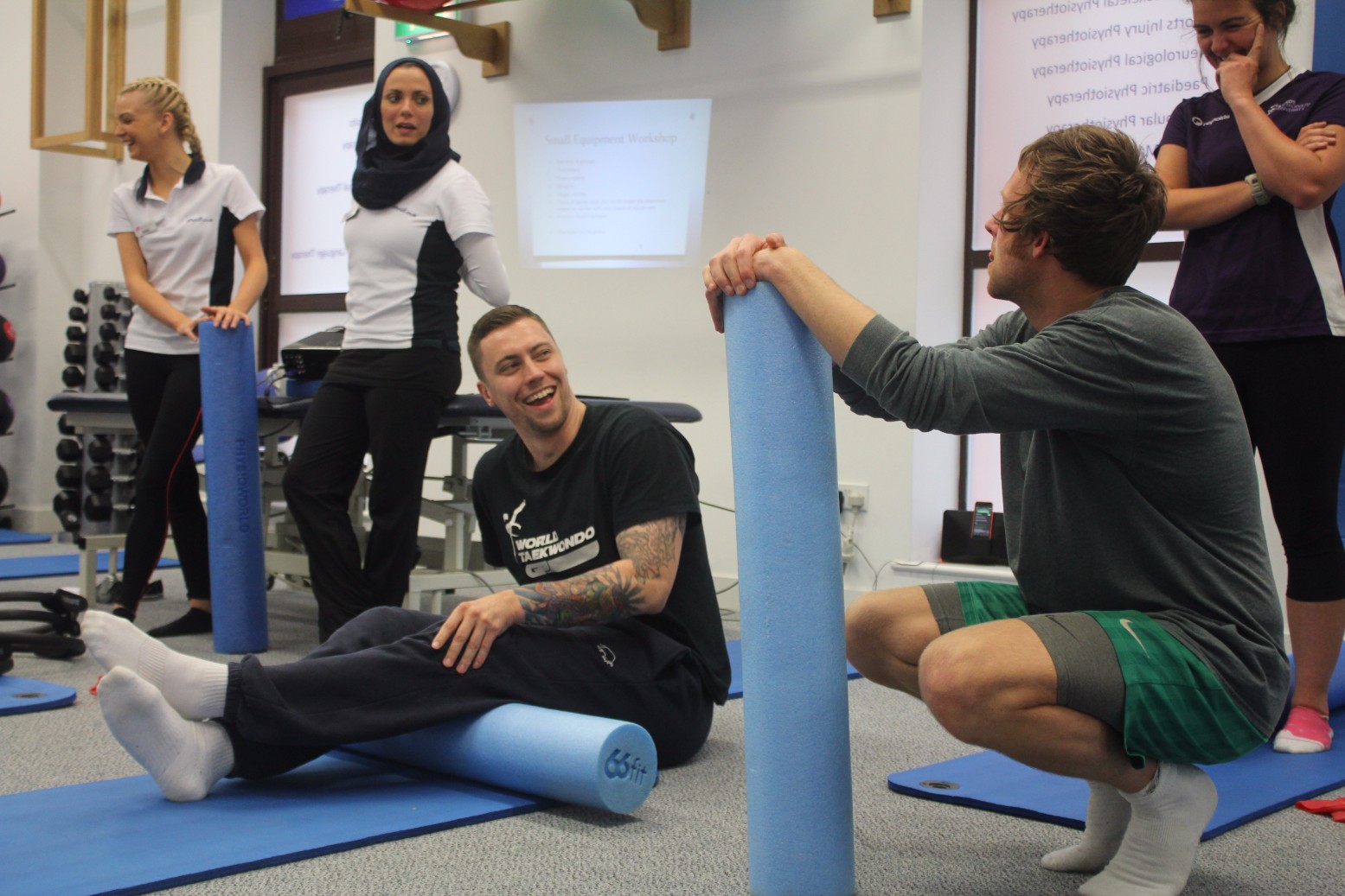 Laughing man sat on foam roller.