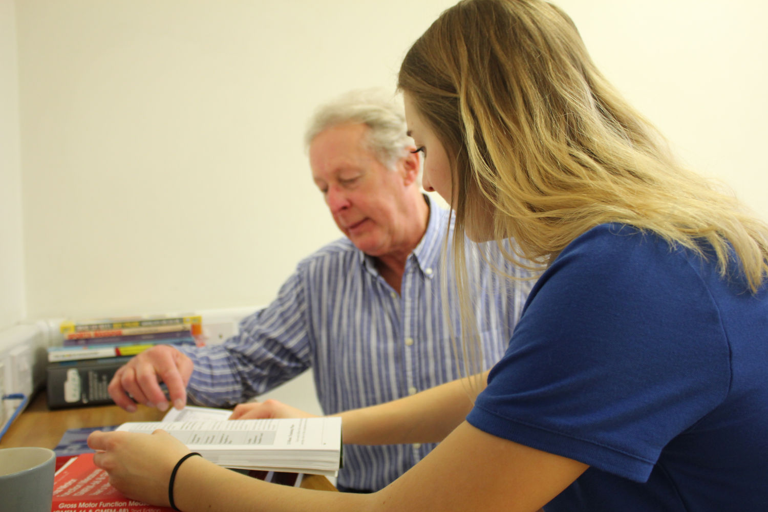 Specialist asking patient to read from books.