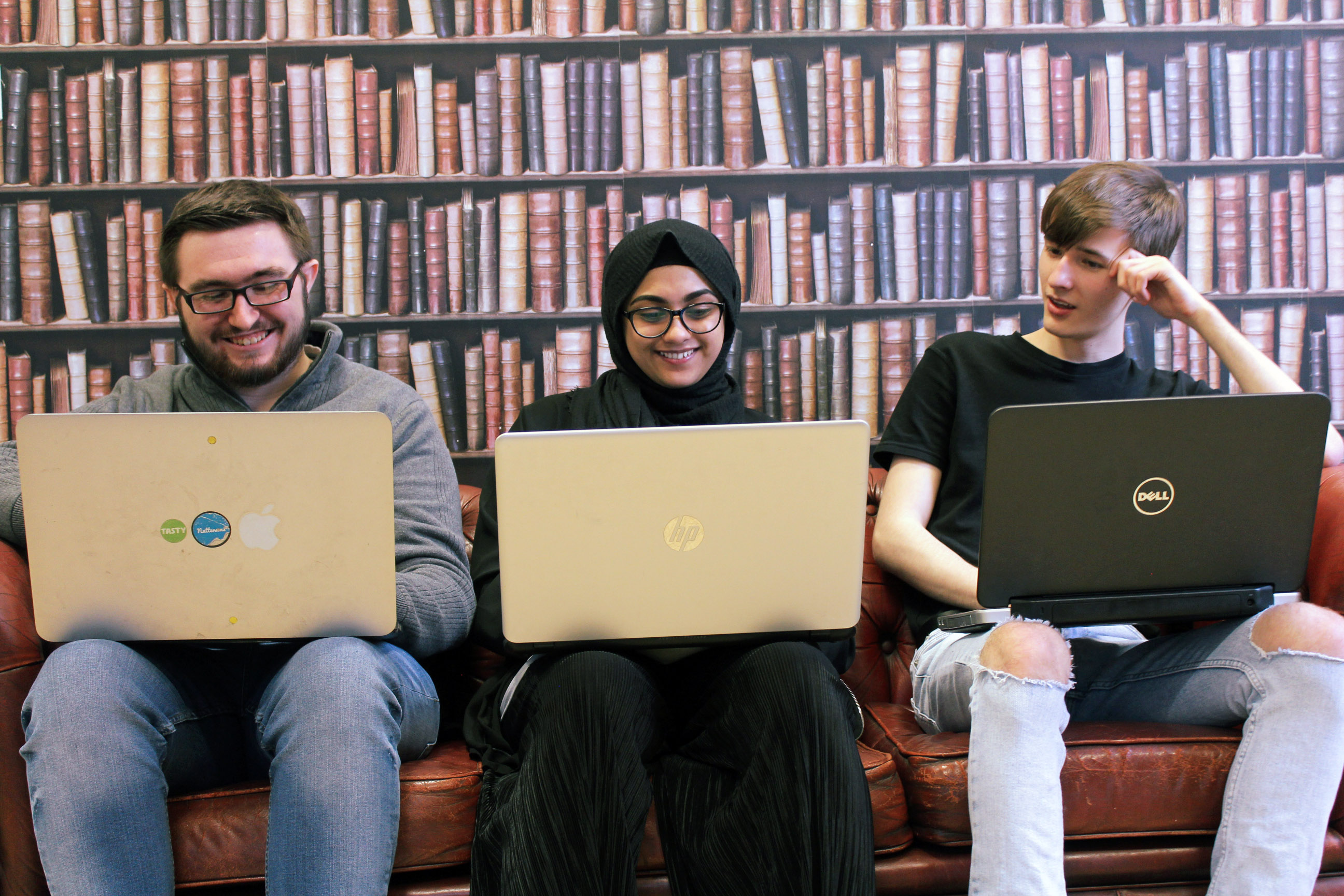 Three web developers sat on settee.